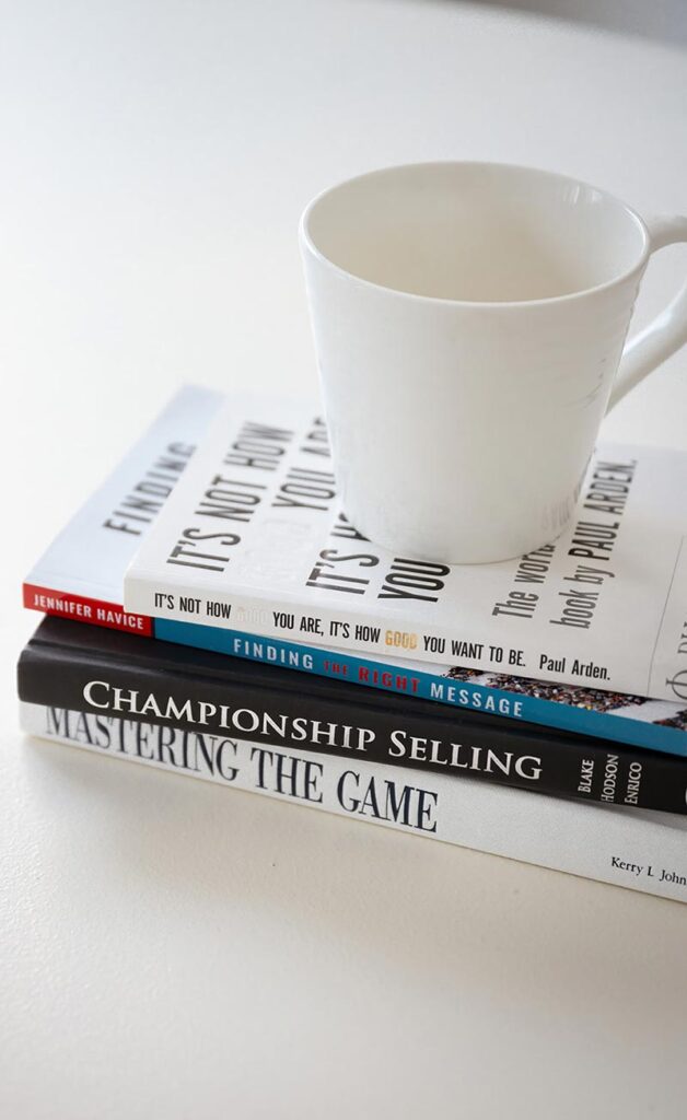 Cup of coffee sitting on top of some marketing books
